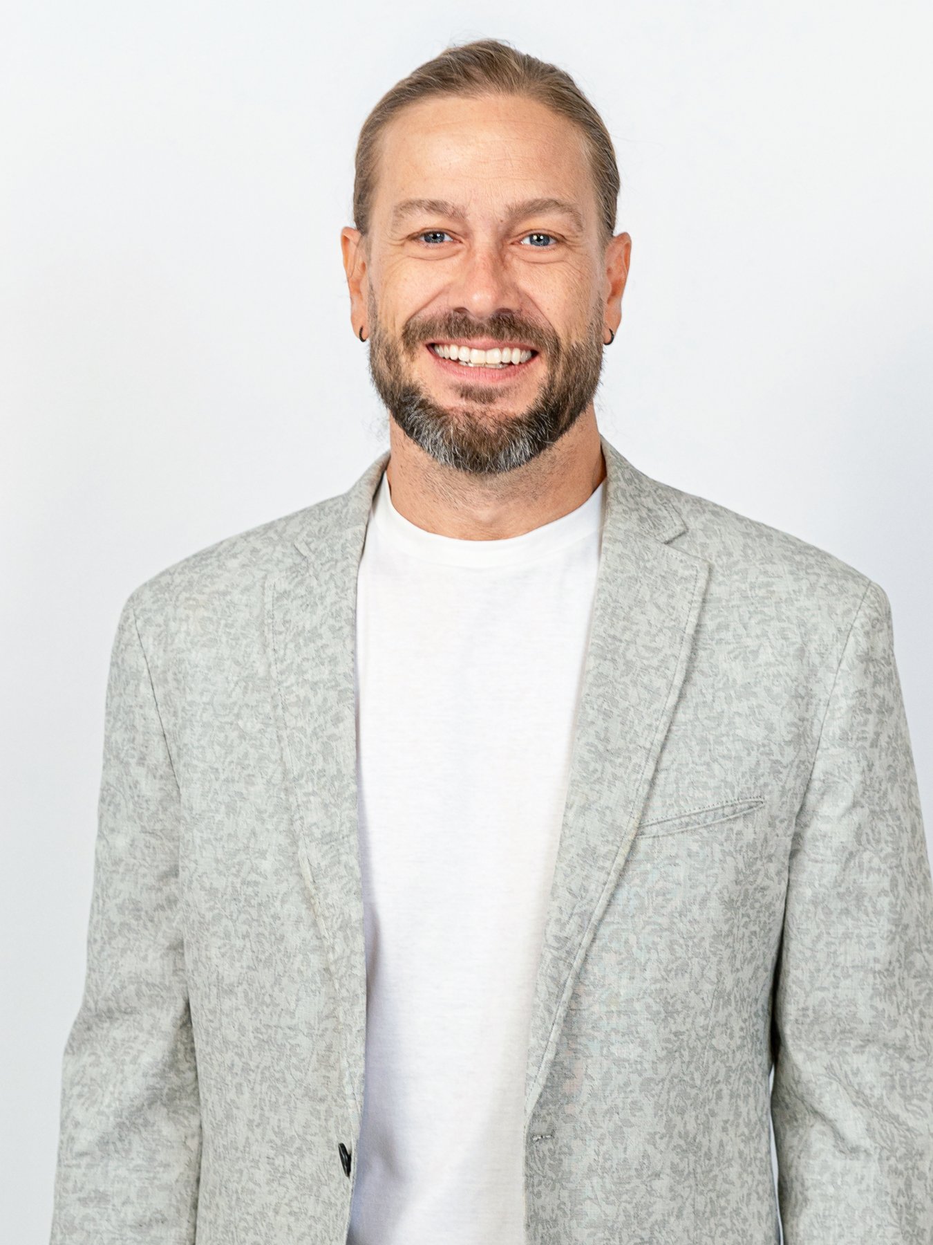 Smiling professional headshot in a light gray blazer