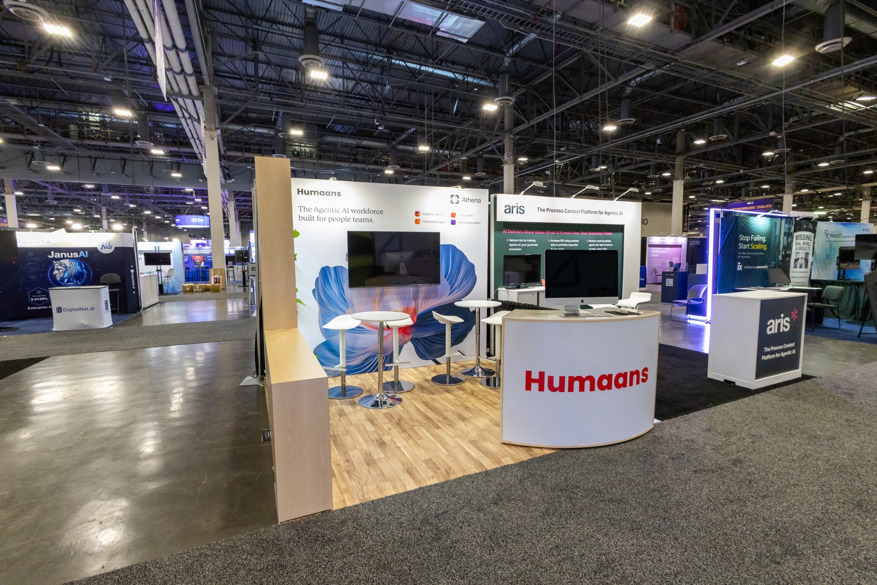 Humaans exhibition booth with wooden counter and illuminated branding