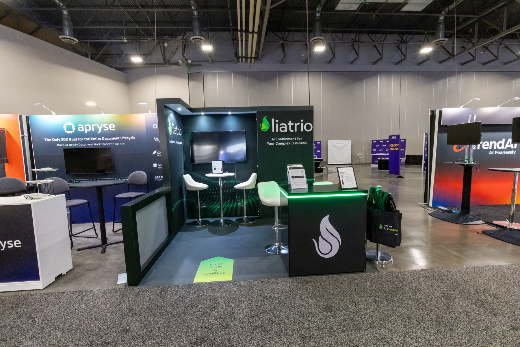 Green and white Latrio exhibition space with screens and seating